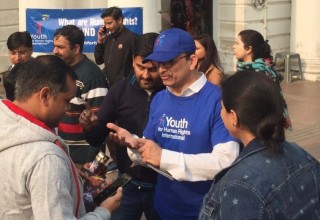 Volunteers hand out copies of human rights booklets