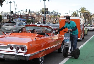 Handing a Truth About Drugs booklet to fans in a vintage Chevy convertible tricked out with the Broncos' team colors