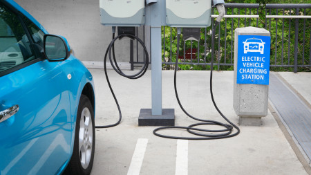 Blue car charging at a level 3 EV charging station in Orange County