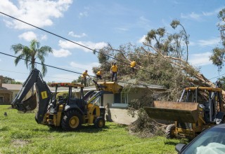   Volunteer Ministers remove a fallen tree from a home in Clearwater's Gateway neighborhood. 