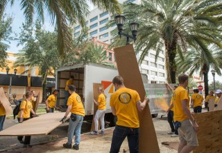 A team of Scientology Volunteer Ministers remove and clear away plywood boards used to secure downtown storefronts from Hurricane Irma.