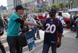 A volunteer hands a copy of The Truth About Drugs to an ardent Broncos fan.