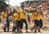 Scientology Volunteer Ministers carry away a massive root under what will now be the foundation of a new home.