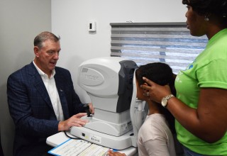 Walman Optical President Marty Bassett gives an eye exam on EVF's new mobile clinic