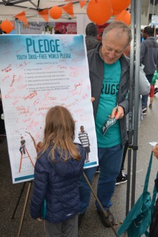 Youngster signs the drug-free pledge at the Drug-Free World booth at British Columbia Recovery Day Festival